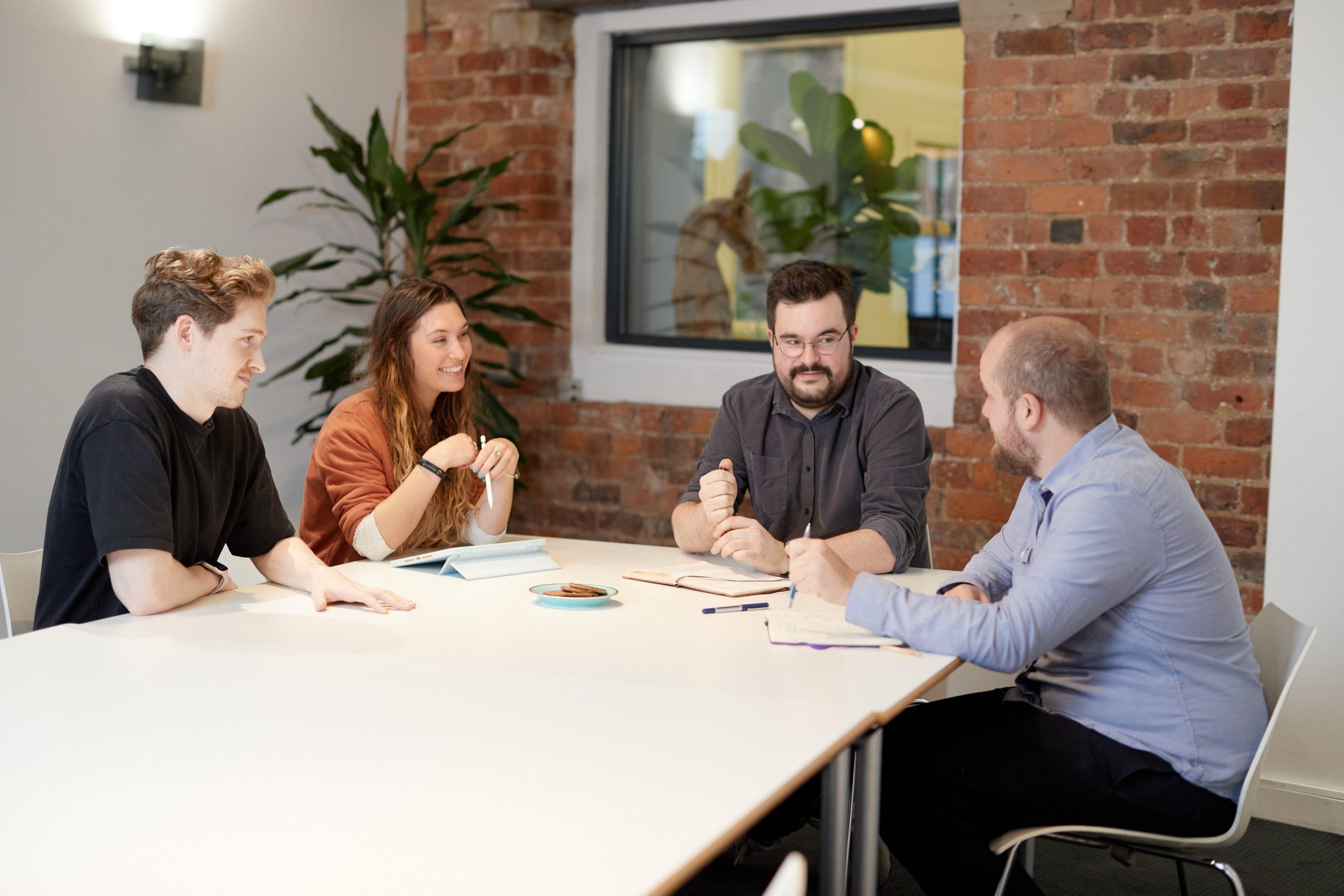 Huddle team sat around a meeting table